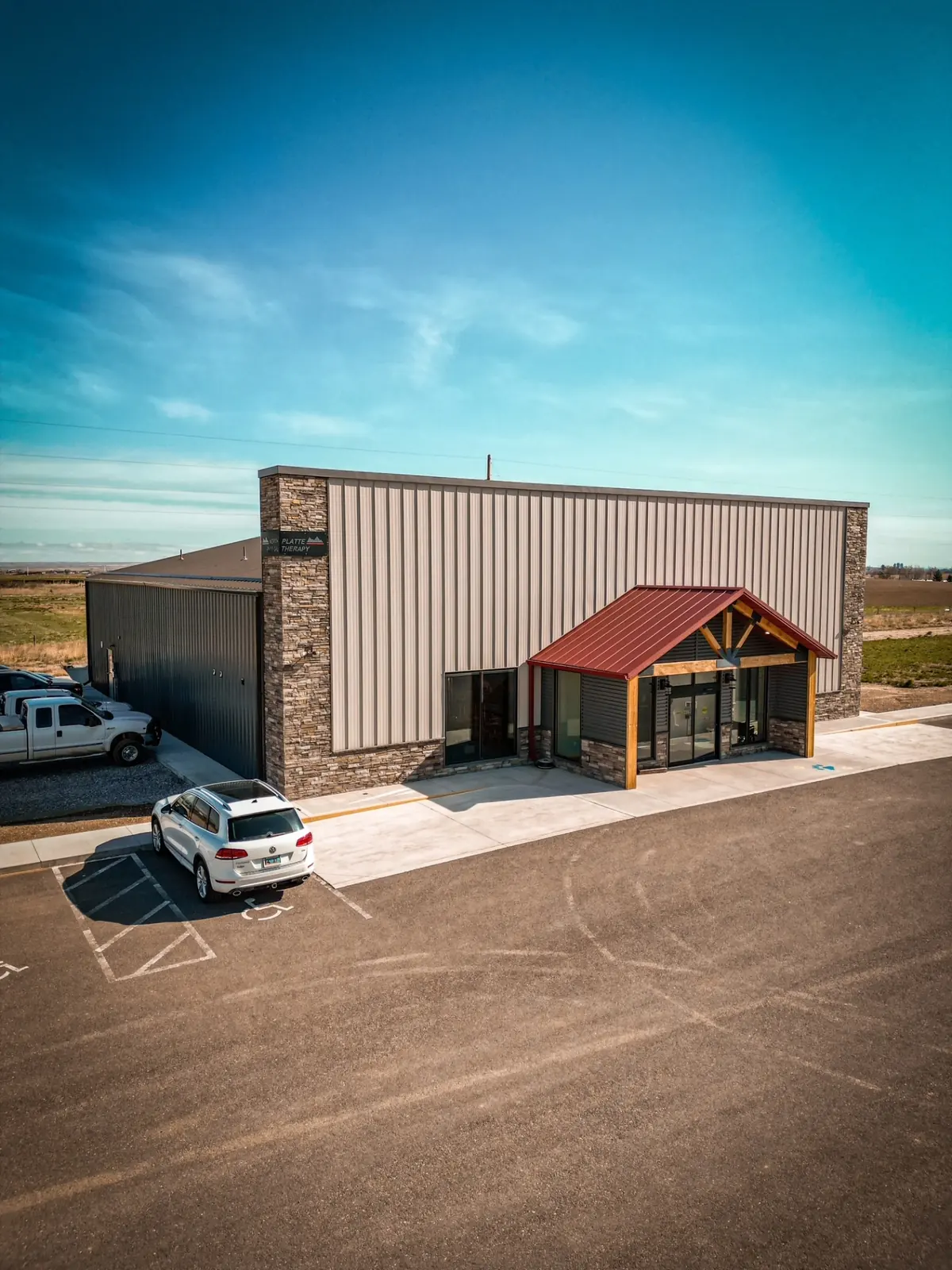 Commercial post-frame building with a stone front and gabled entry