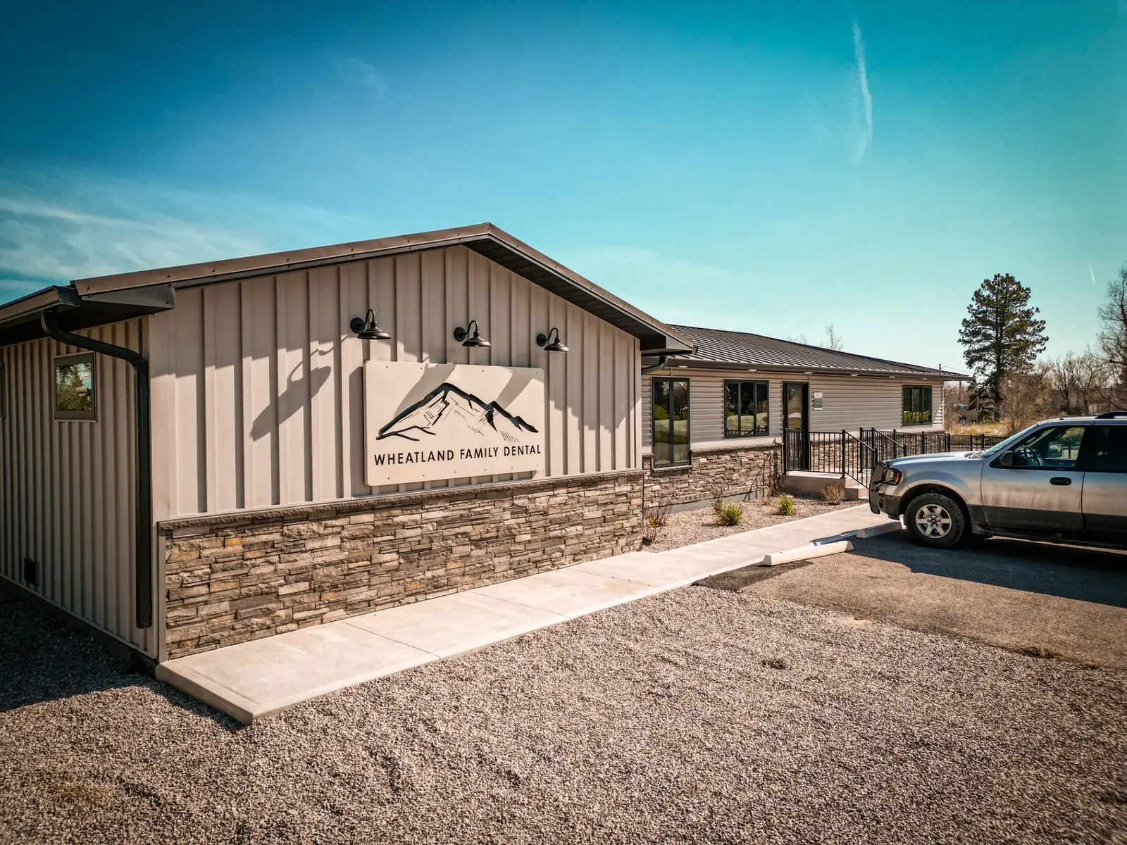 Post-frame commercial building with stone wainscot and a covered entry