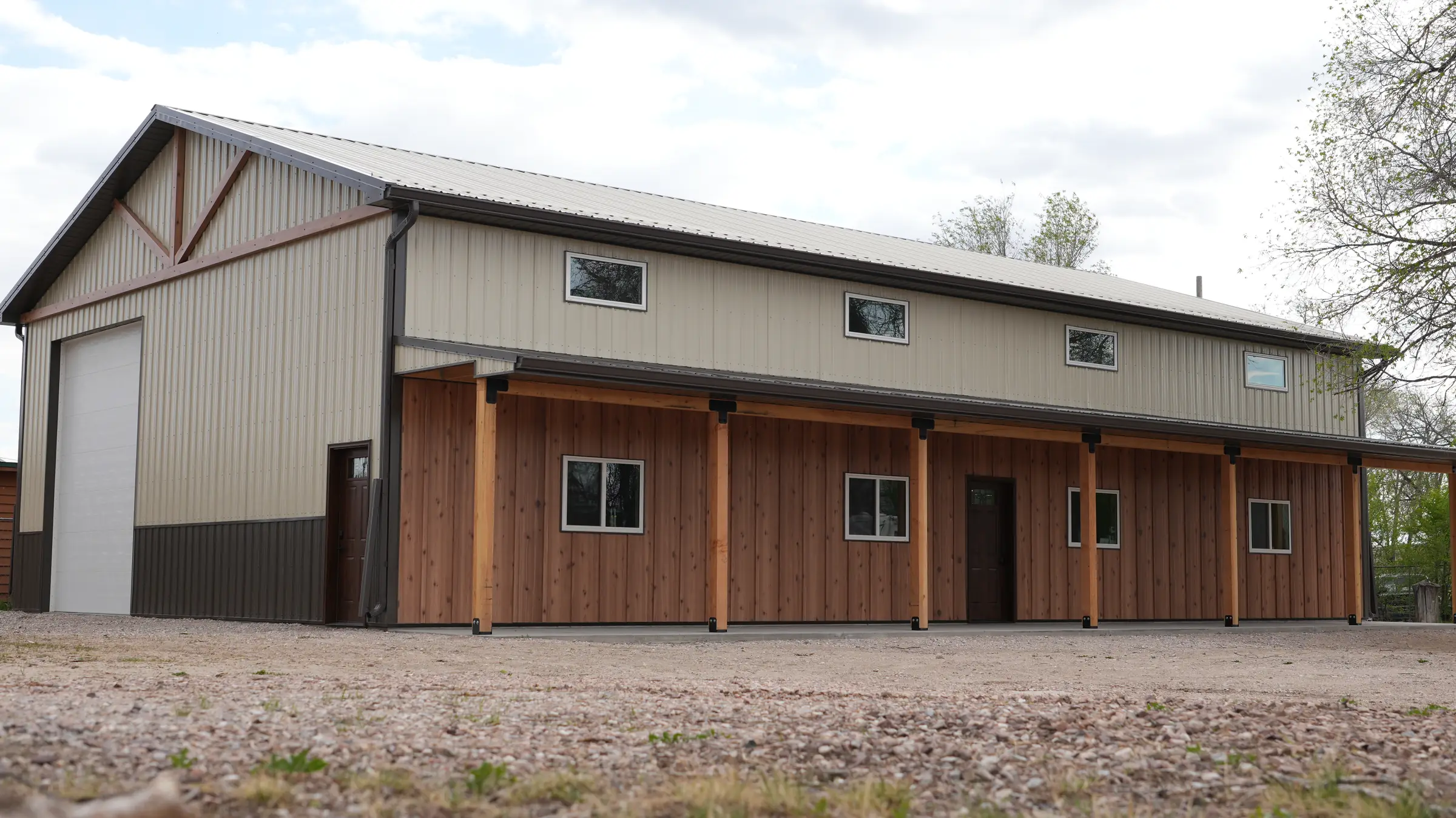 Post-frame shop with wood-look siding and a timber-post porch, built from a Western Building Supply kit